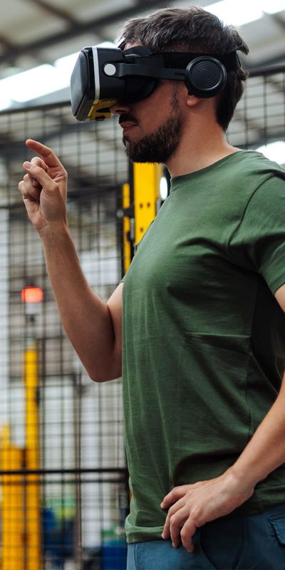 Industrial engineer wearing vr headset controlling robotic arm in factory